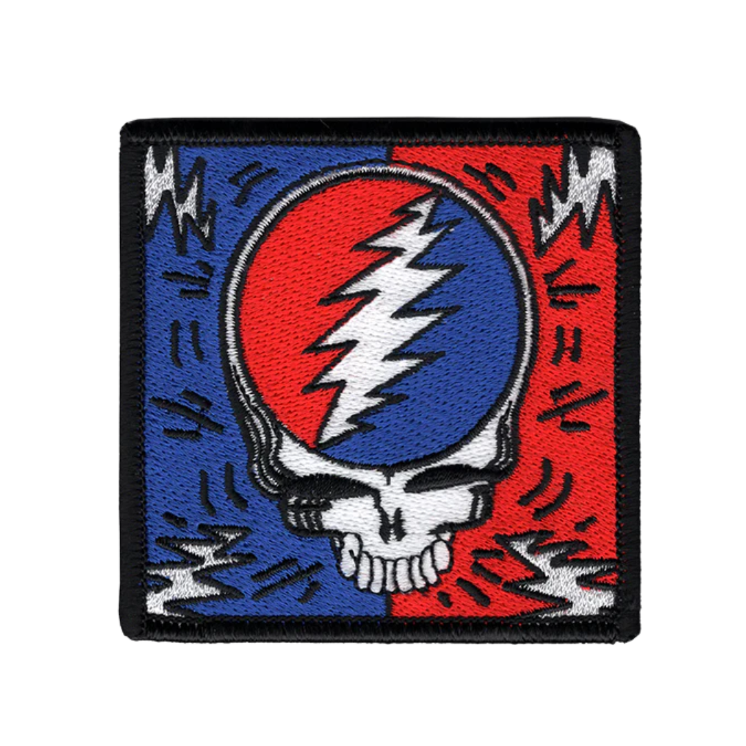 Patch with a skull and lightning bolt design on a red, blue, and white background.