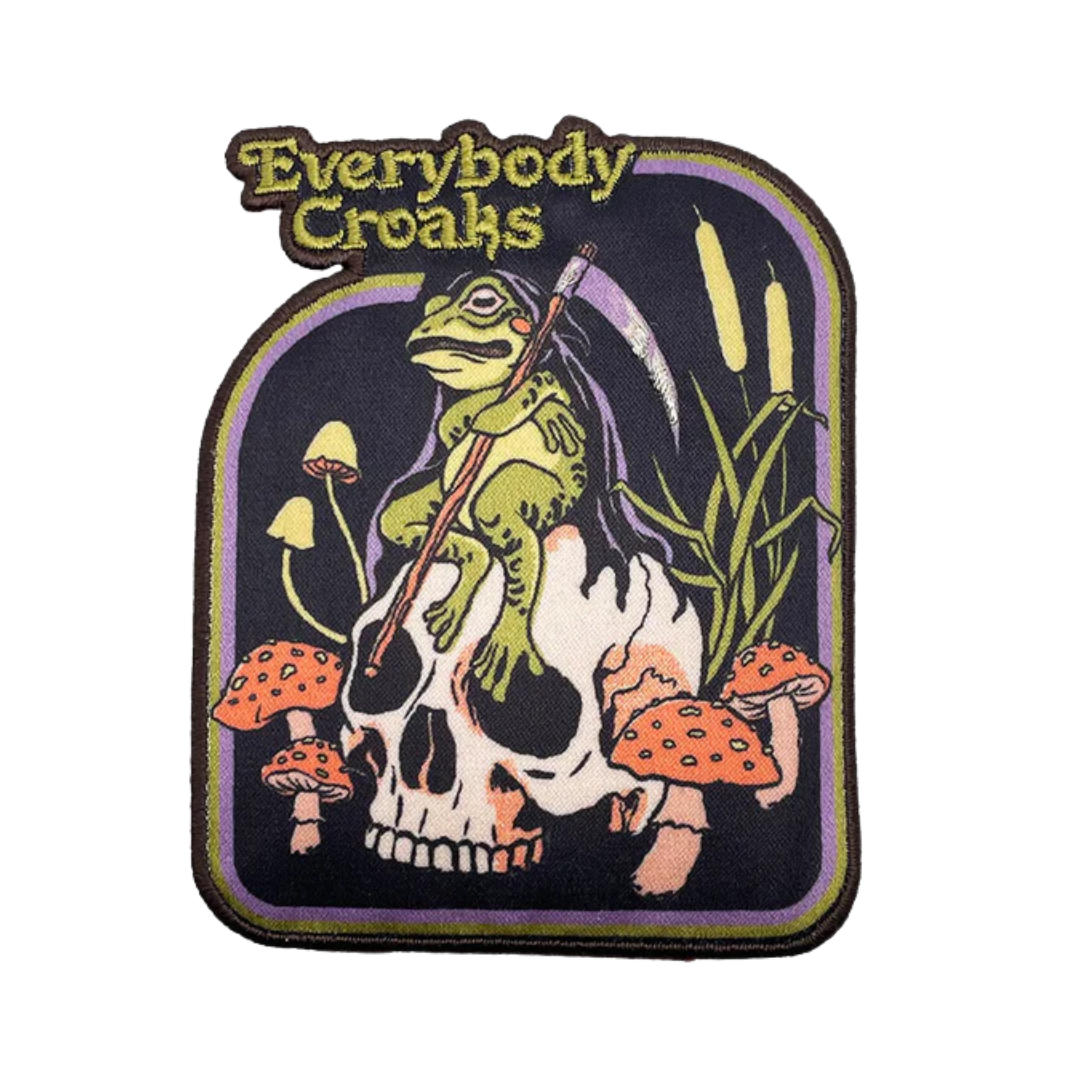 Patch with a frog, skull, and mushrooms design and 'Everybody Croaks' text on a white background.